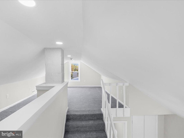 staircase featuring lofted ceiling and carpet floors