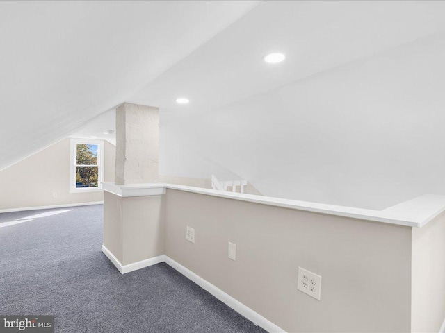 interior space with lofted ceiling and dark carpet