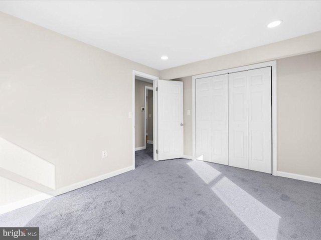 unfurnished bedroom featuring a closet and dark carpet