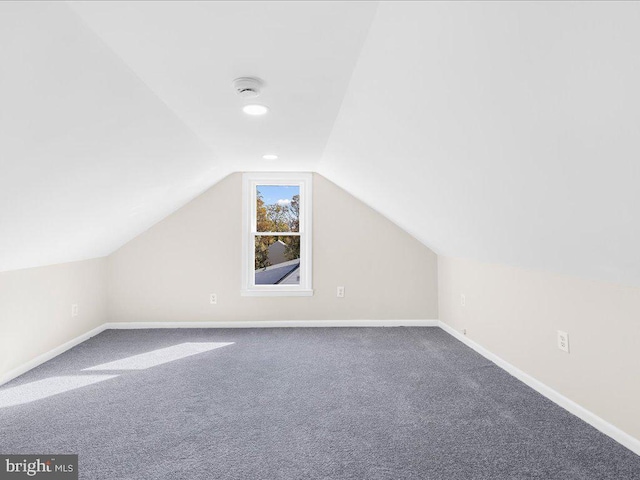 additional living space featuring carpet and lofted ceiling