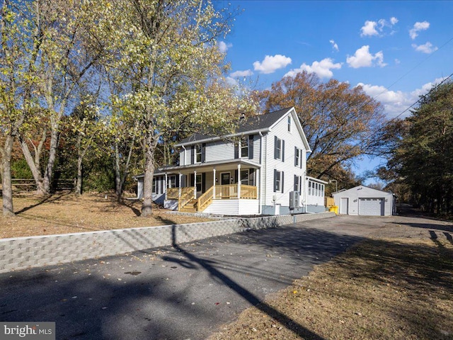 view of front of home with a garage, an outdoor structure, and a porch