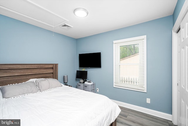 bedroom featuring dark hardwood / wood-style flooring and a closet