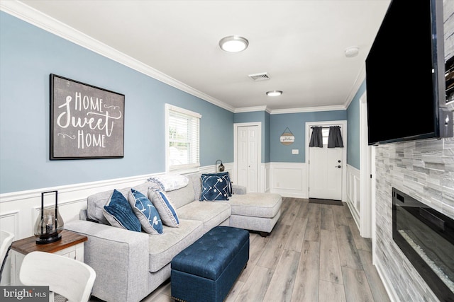 living room with light wood-type flooring and ornamental molding