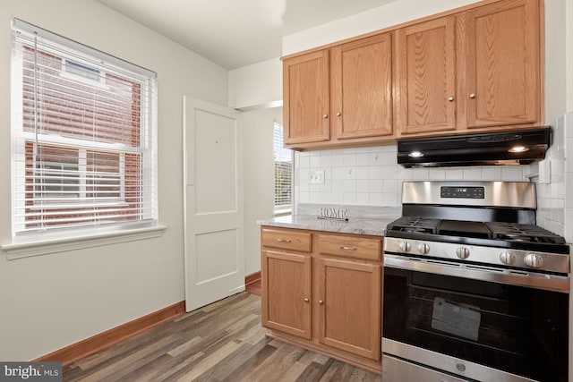 kitchen with a wealth of natural light, backsplash, stainless steel range with gas stovetop, and dark hardwood / wood-style flooring