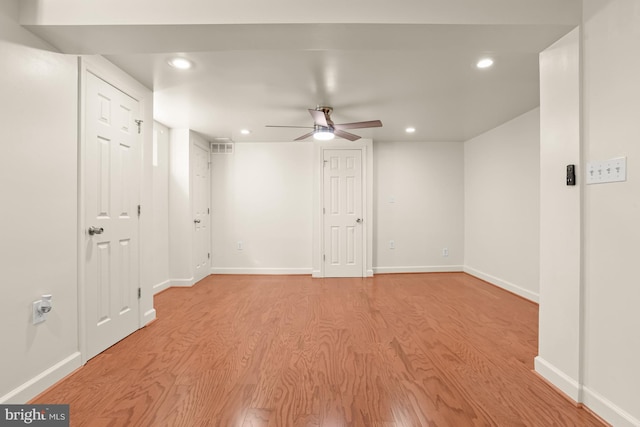 basement featuring light hardwood / wood-style floors and ceiling fan