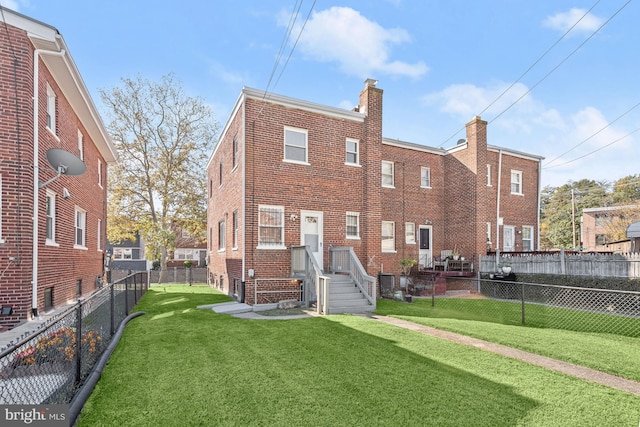 rear view of house featuring a yard