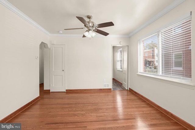 spare room with ceiling fan, hardwood / wood-style flooring, and crown molding