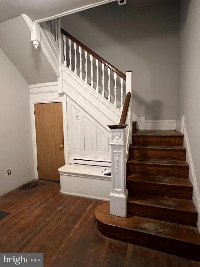 staircase featuring wood-type flooring and baseboard heating