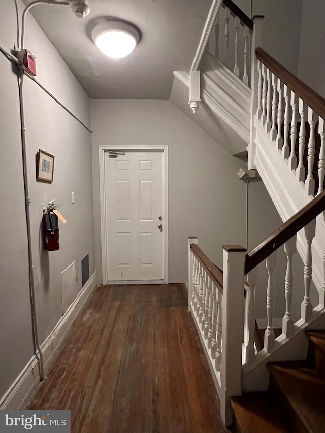 interior space featuring dark wood-type flooring and vaulted ceiling