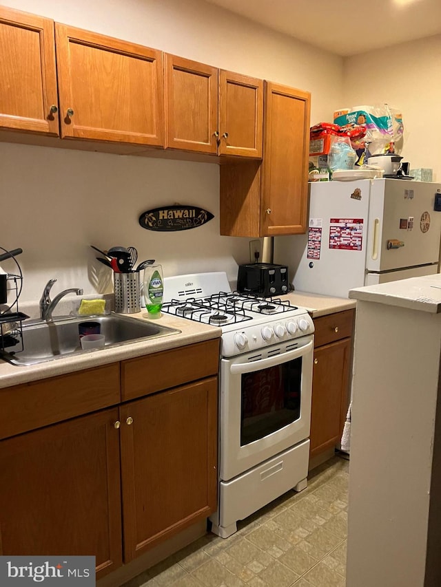 kitchen featuring white appliances and sink