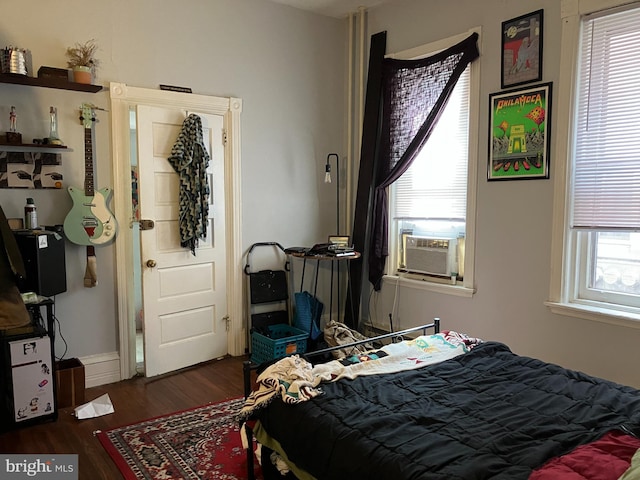 bedroom with multiple windows, cooling unit, and dark wood-type flooring