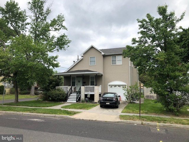 view of front of house featuring a garage, a front lawn, and covered porch