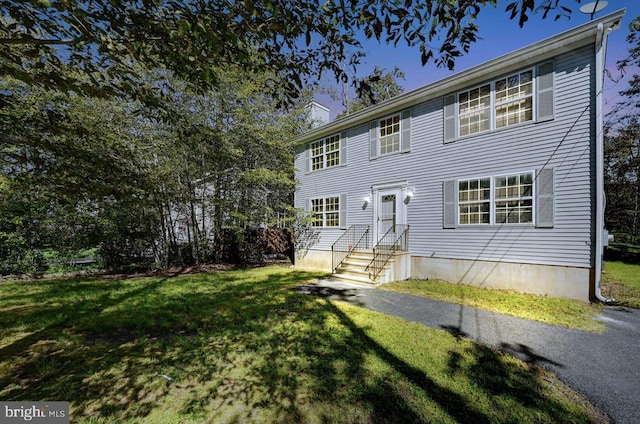 colonial home with a front lawn