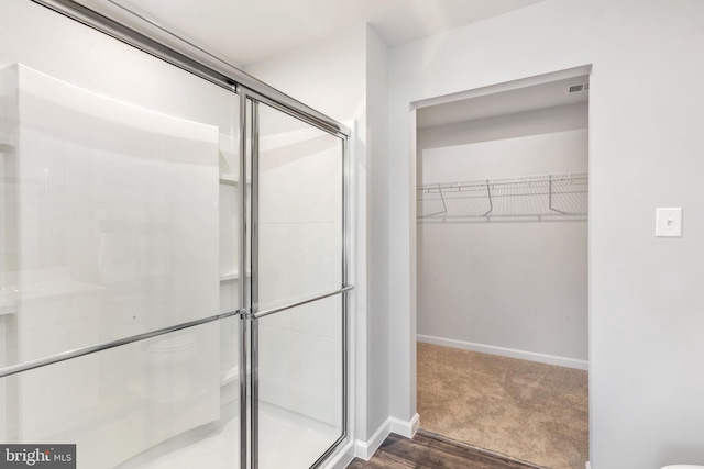 bathroom featuring wood-type flooring and an enclosed shower