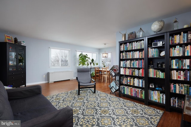 living area with baseboards and wood finished floors