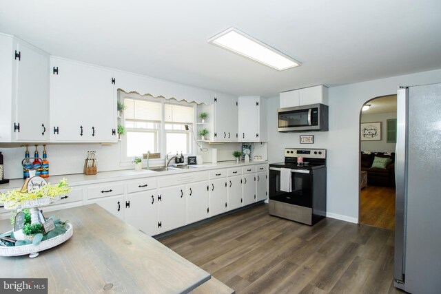 kitchen featuring dark hardwood / wood-style flooring, stainless steel appliances, sink, and white cabinetry