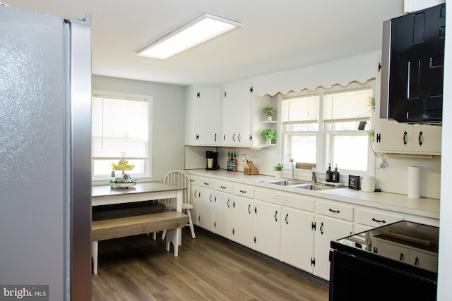 kitchen with a healthy amount of sunlight, sink, dark hardwood / wood-style floors, and white cabinetry