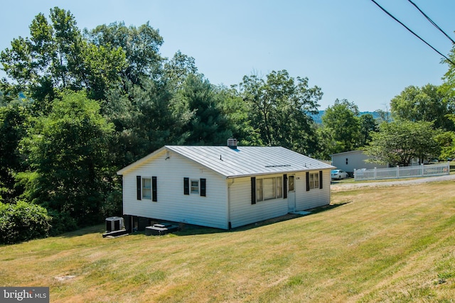 view of property exterior featuring a yard and central AC