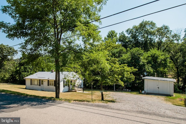 view of front facade featuring a front yard and a storage unit