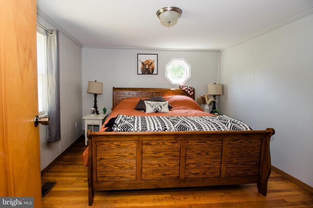 bedroom featuring crown molding and dark wood-type flooring