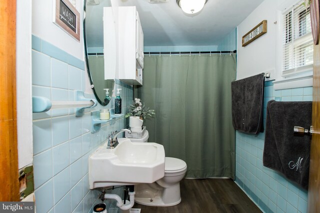 bathroom with curtained shower, tile walls, toilet, sink, and hardwood / wood-style flooring