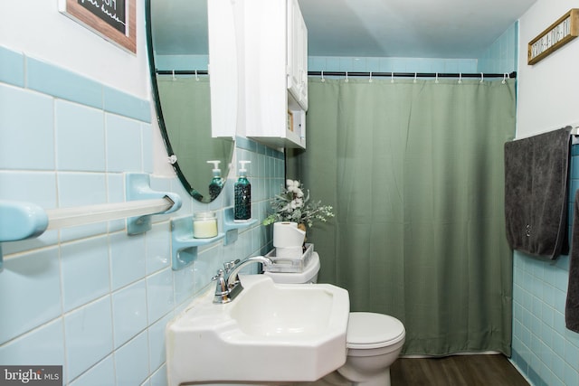 bathroom featuring backsplash, tile walls, toilet, sink, and hardwood / wood-style flooring