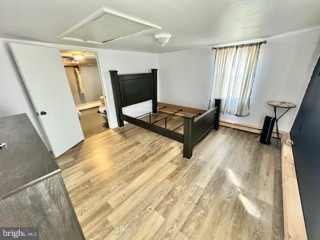 bedroom with hardwood / wood-style flooring and a baseboard radiator