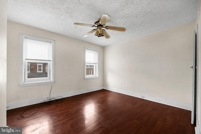 empty room with dark hardwood / wood-style flooring, ceiling fan, and a textured ceiling