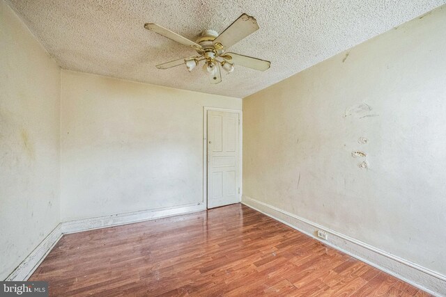 spare room with a textured ceiling, ceiling fan, and hardwood / wood-style flooring