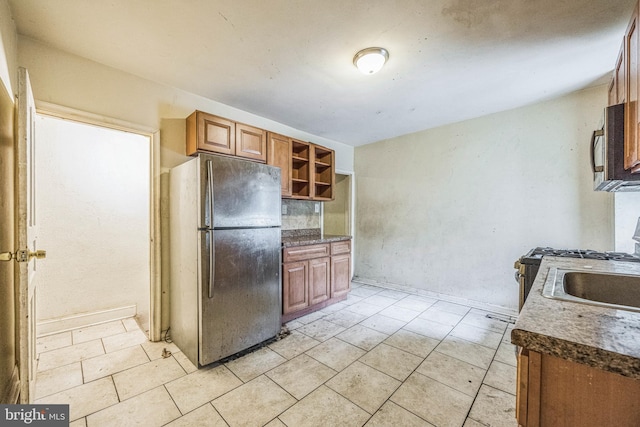 kitchen featuring stainless steel appliances, sink, and light tile patterned floors