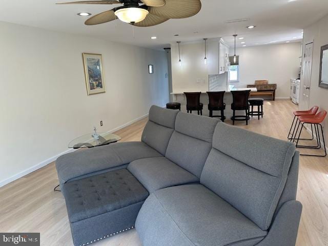 living room featuring ceiling fan and light wood-type flooring