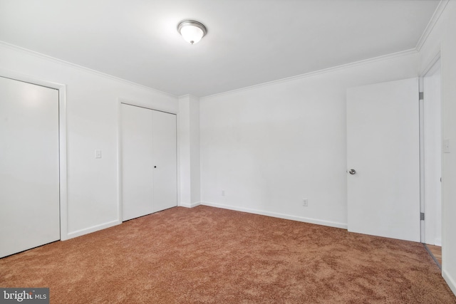 unfurnished bedroom featuring carpet floors, ornamental molding, and a closet