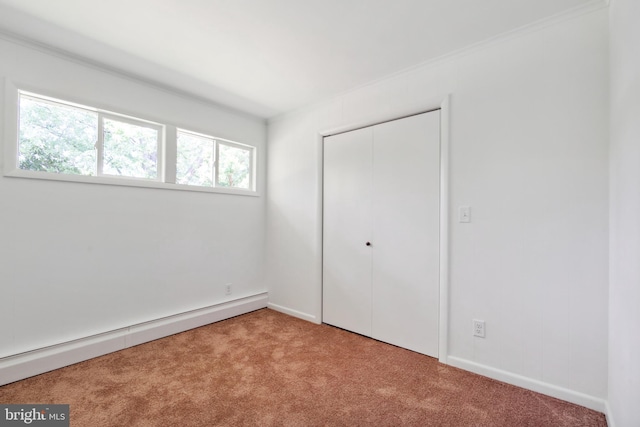 unfurnished bedroom with a closet, light colored carpet, and a baseboard radiator