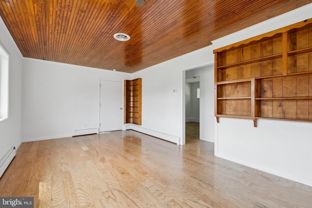 spare room with light wood-type flooring and a baseboard heating unit