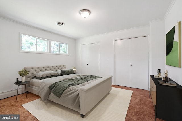 bedroom featuring multiple closets, light colored carpet, and crown molding