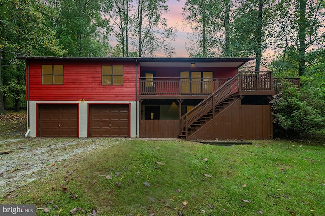 view of front of home with a lawn, a garage, and a deck