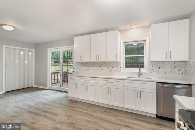 kitchen featuring stove, light wood-type flooring, sink, dishwasher, and white cabinetry