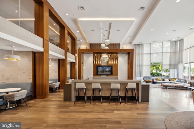 interior space featuring a high ceiling, hardwood / wood-style floors, and a kitchen breakfast bar