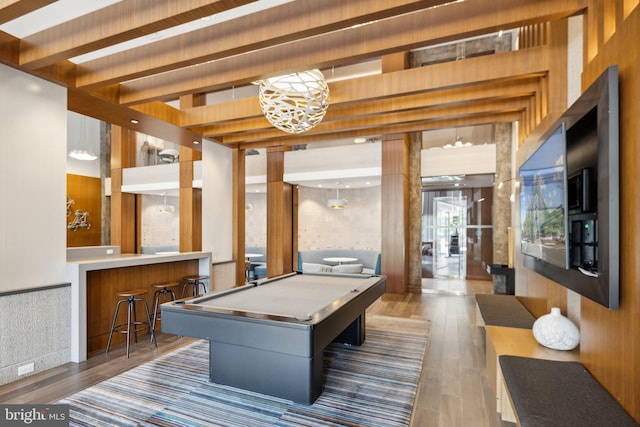 recreation room with dark hardwood / wood-style flooring, billiards, bar, and beamed ceiling