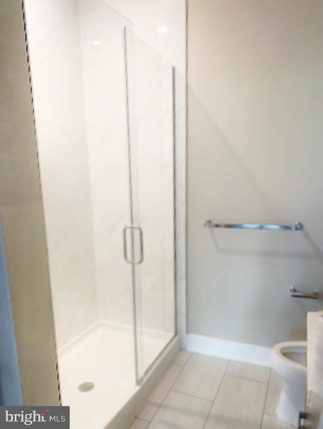 bathroom featuring toilet, walk in shower, and tile patterned flooring