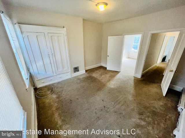 unfurnished bedroom with dark colored carpet