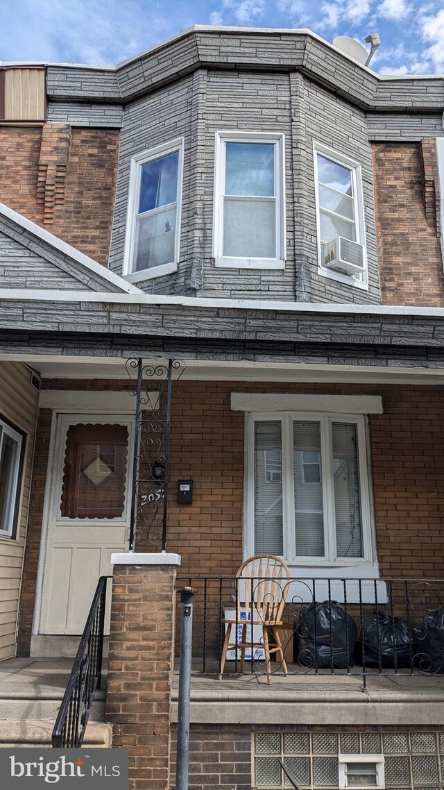 townhome / multi-family property featuring cooling unit and covered porch