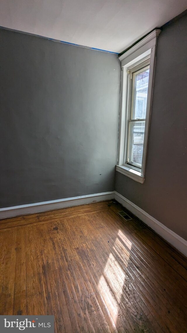 empty room with dark hardwood / wood-style flooring