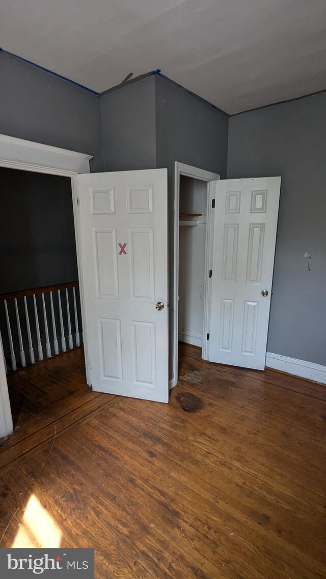 unfurnished bedroom featuring dark wood-type flooring and a closet