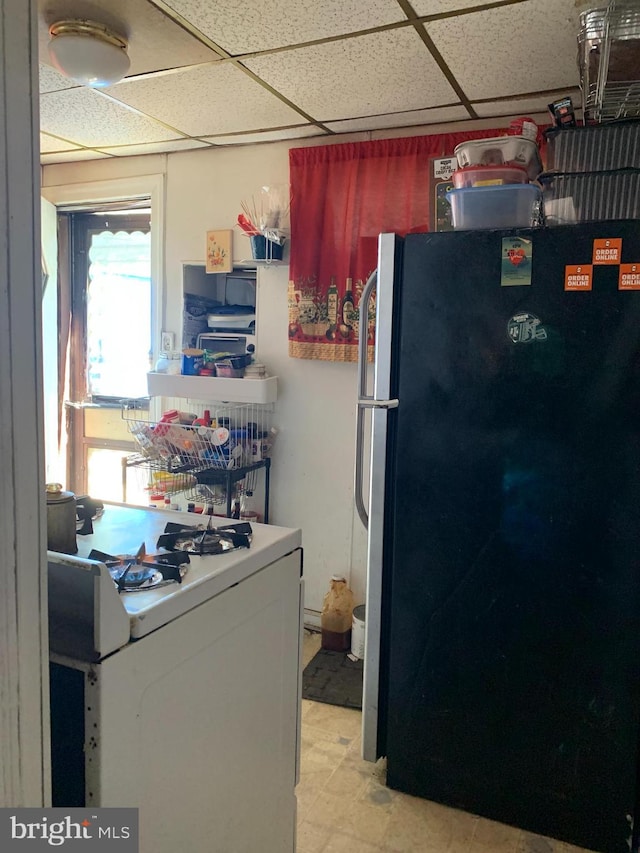 kitchen featuring stainless steel fridge and a paneled ceiling