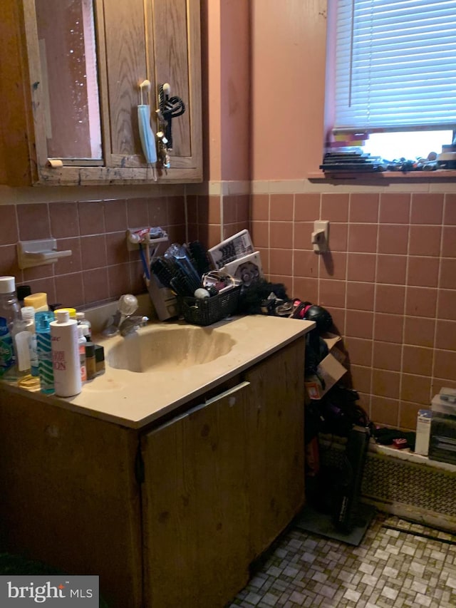 bathroom with vanity and tile walls