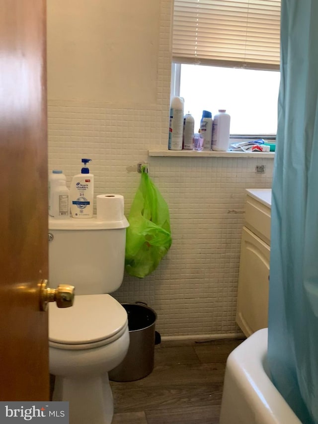 bathroom with vanity, tile walls, and toilet