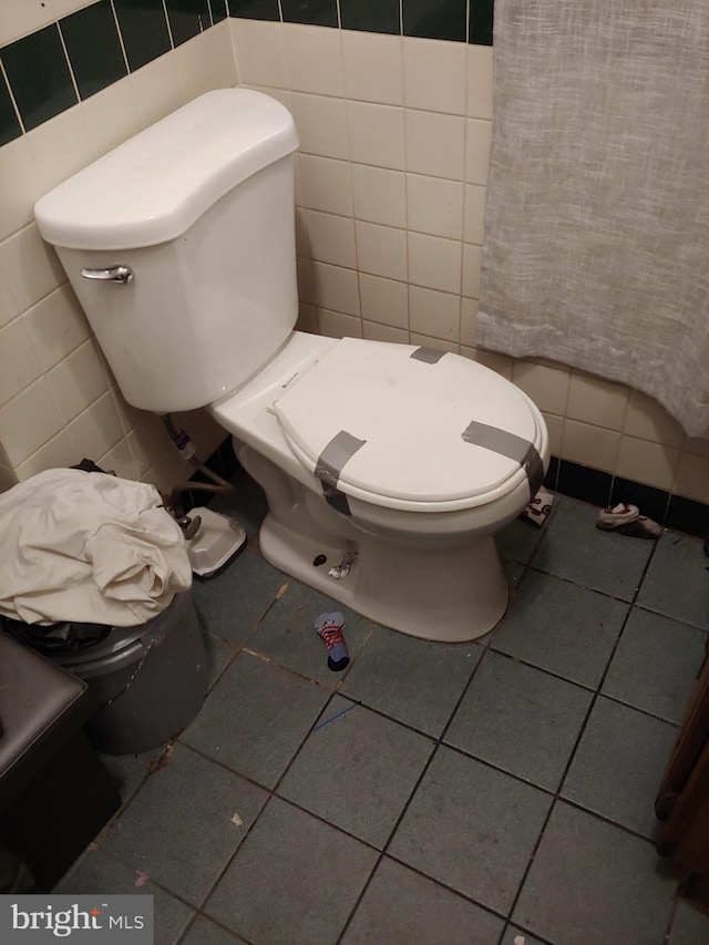 bathroom featuring tile walls, tile patterned floors, and toilet