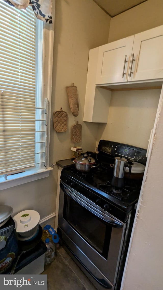 kitchen featuring white cabinetry and black range with gas stovetop