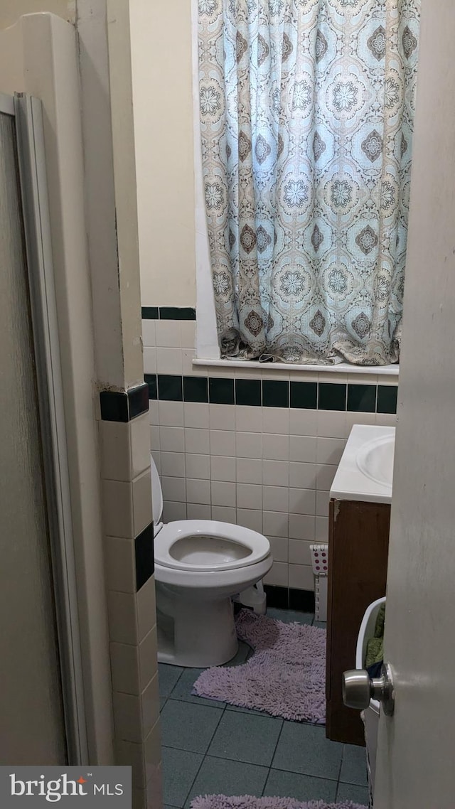 bathroom featuring tile walls, tile patterned flooring, vanity, and toilet